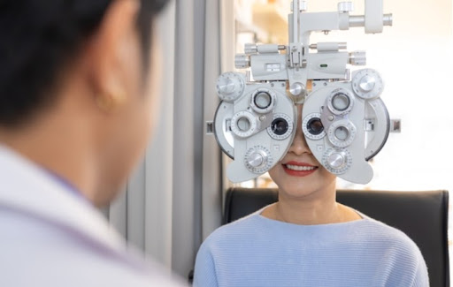 An optometrist performing a refraction test on a female patient to look for astigmatism