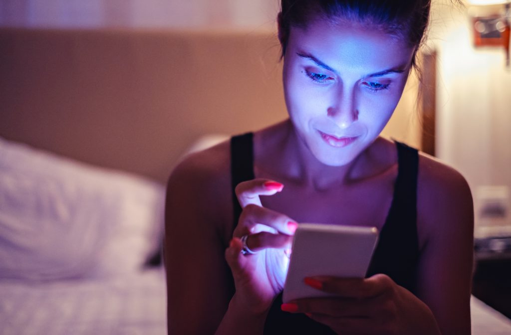 Woman looking at a phone screen in dimmed light