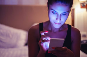 Woman looking at a phone screen in dimmed light