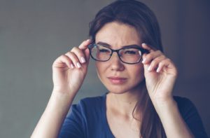 A woman with eyesight problems sees poorly through glasses because of astigmatism