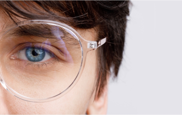 An up-close of the left eye of a woman wearing translucent eyeglasses frames