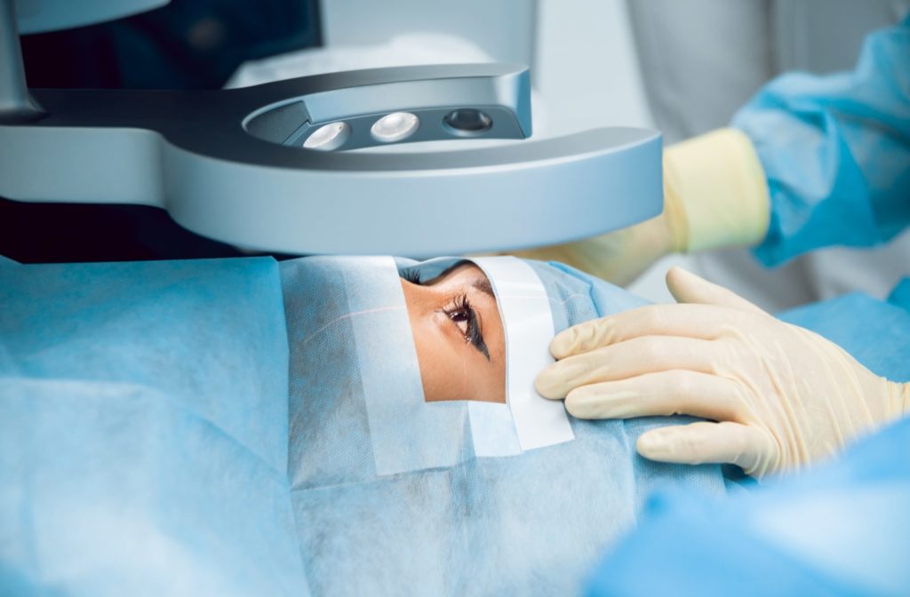 A woman preparing for a cataract operation while the surgeon preps the work area