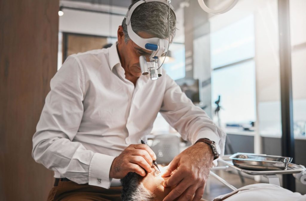 An ophthalmologist performs surgery on a patient's eye to remove the cataract and replace it with a new intraocular lens.