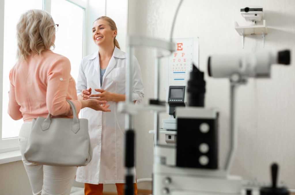 a patient speaks with their eye doctor in the optometrist clinic.