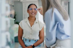 An optometrist helping a patient adjust their glasses.