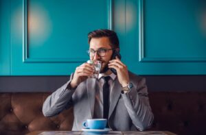 A business professional drinks a glass of water while on a work break to support eye health during long days of screen use