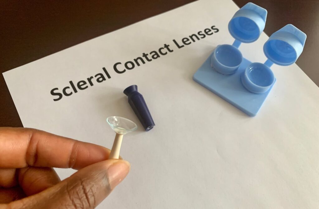 A close-up image of someone holding a scleral lens on an applicator.