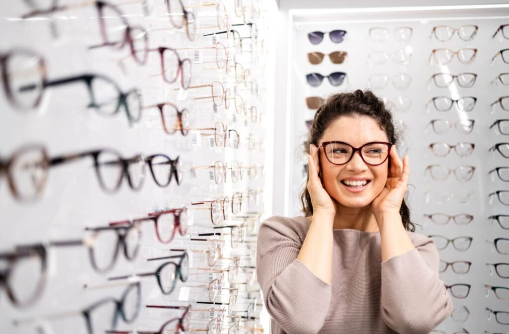 A person trying on eyeglasses in an optical store.