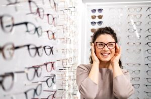 A person trying on eyeglasses in an optical store.